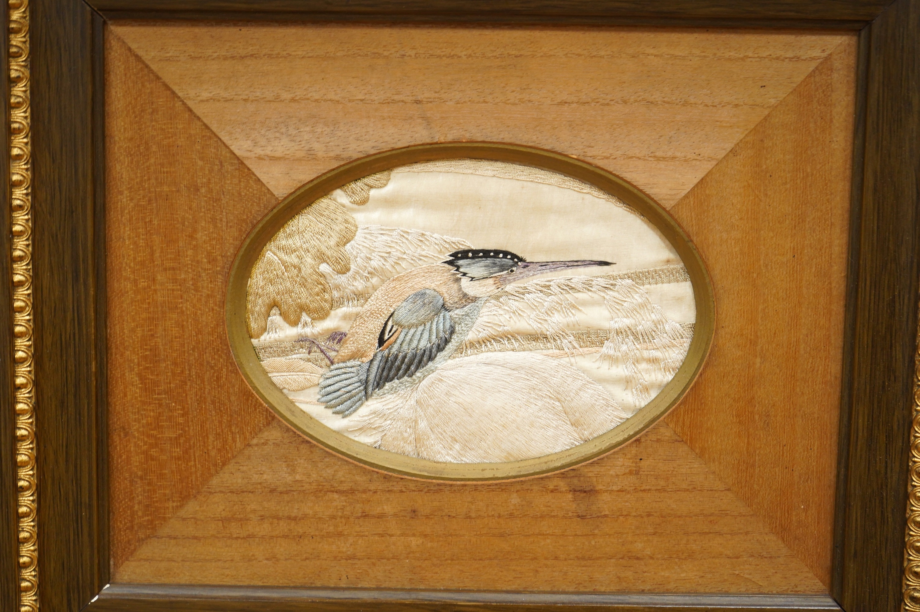 A pair of framed early 20th century Japanese oval silk embroideries of Kingfishers, embroidered on cream silk in pastel shades of silk thread, in a variety of stitches, various parts of each bird slightly couched giving